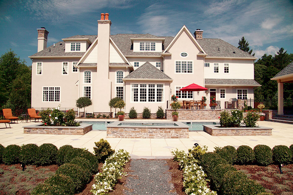 back of large white mansion with pool